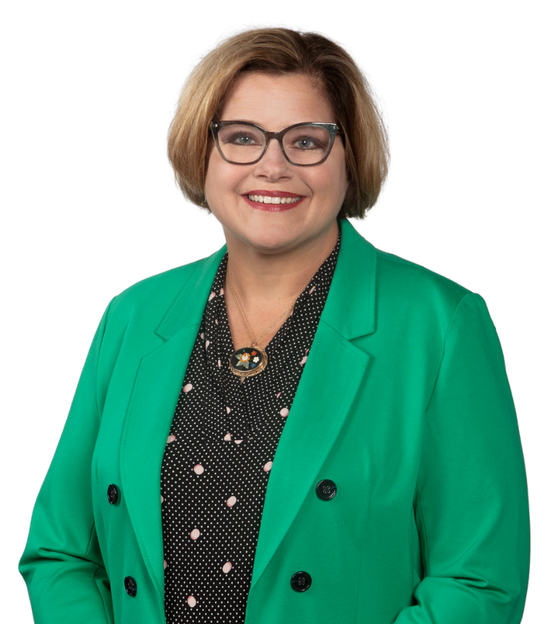 A photo of attorney Jeanne L. Vance wearing a bright green business jacket with black and white dotted dress shirt, wearing glasses